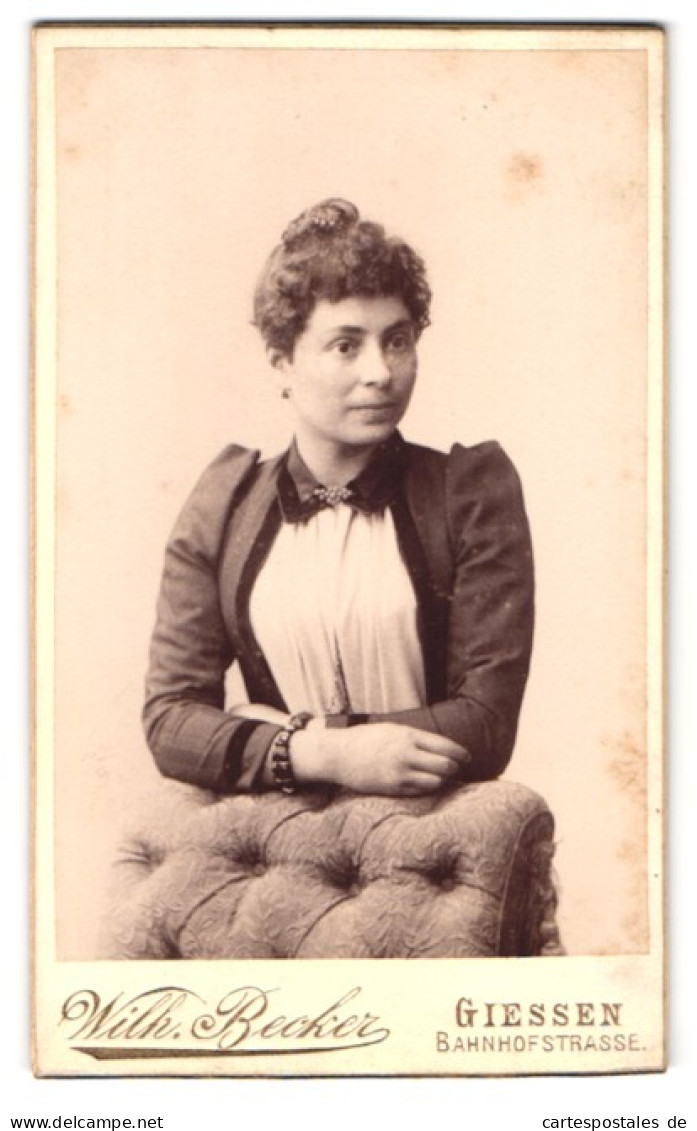 Fotografie Wilh. Becker, Giessen, Bahnhofstr., Portrait Junge Frau Im Kleid Mit Locken Lehnt An Einem Sessel  - Anonymous Persons