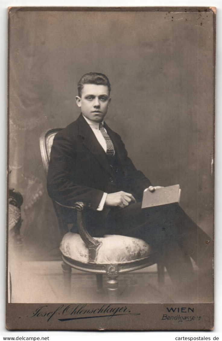 Fotografie Josef Ohlenschlager, Wien, Portrait Sitzender Herr Im Anzug Mit Krawatte Und Buch  - Anonyme Personen