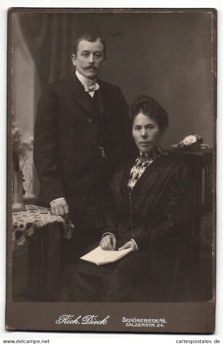 Fotografie Rich. Dieck, Schönebeck A / E., Portrait Elegant Gekleidetes Paar Mit Buch Am Tisch  - Anonyme Personen