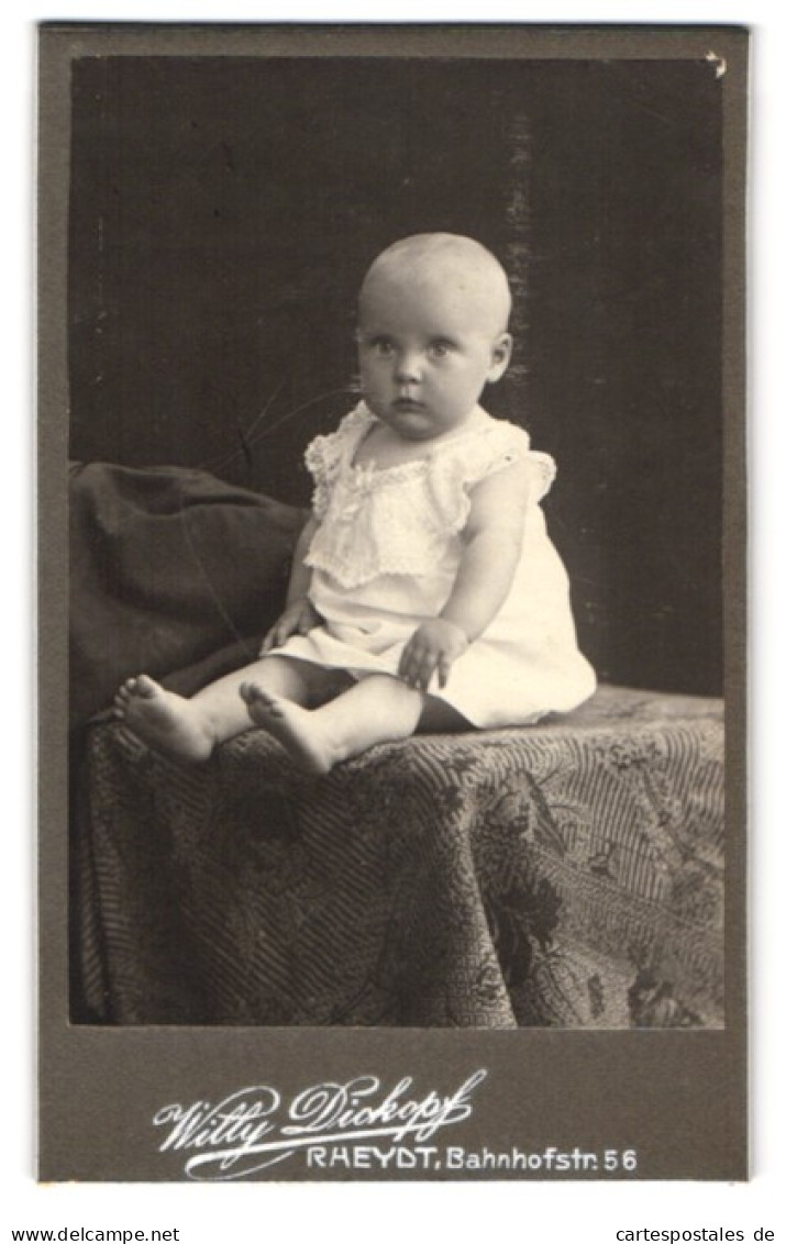 Fotografie Willy Dickopf, Rheydt, Bahnhofstr. 56, Niedliches Proppes Kleinkind Im Weissen Kleid Mit Fragendem Blick  - Personas Anónimos