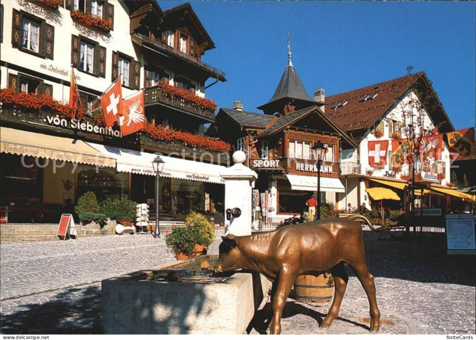 12454940 Gstaad Dorfstrasse Hotel Bronzefigur Brunnen Gstaad - Sonstige & Ohne Zuordnung