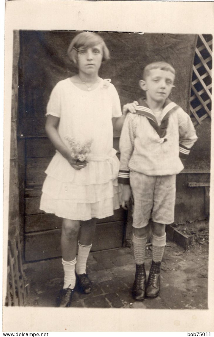 Carte Photo D'une Jeune Fille élégante Avec Un Petit Garcon Posant Devant L'entré De Leurs Maison - Anonieme Personen