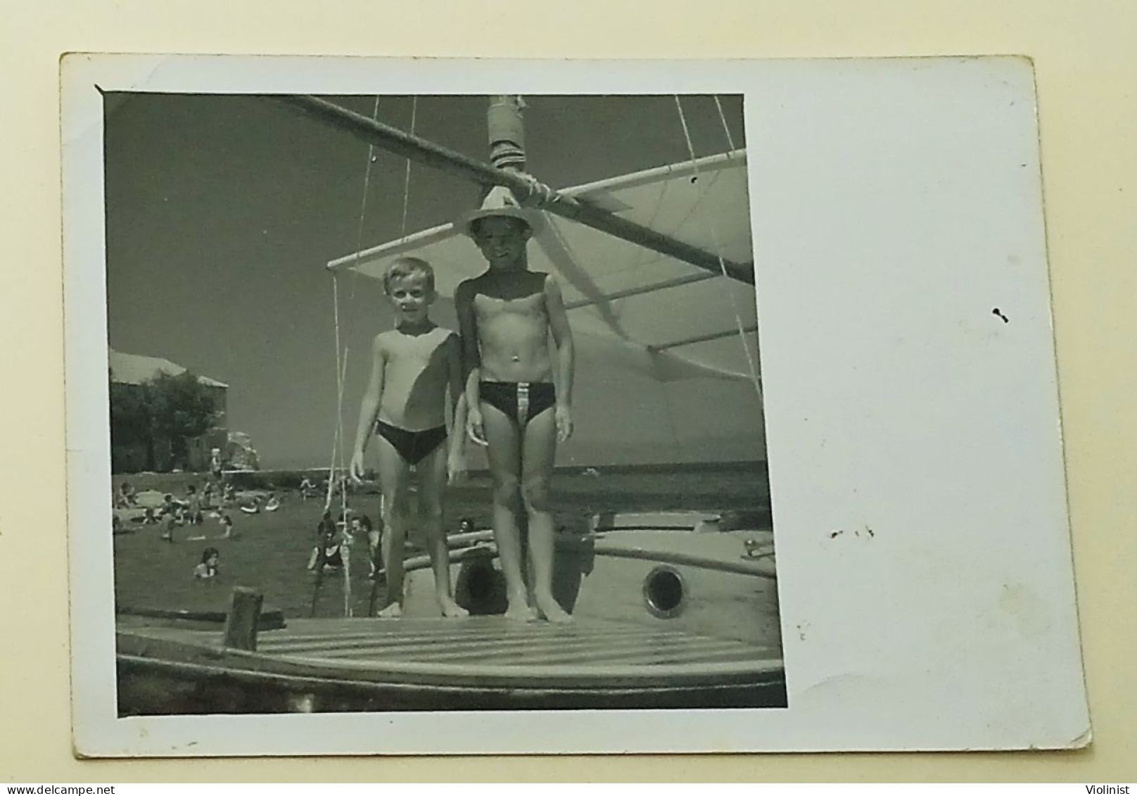 Two Boys Are Standing On A Boat At Sea - Personnes Anonymes