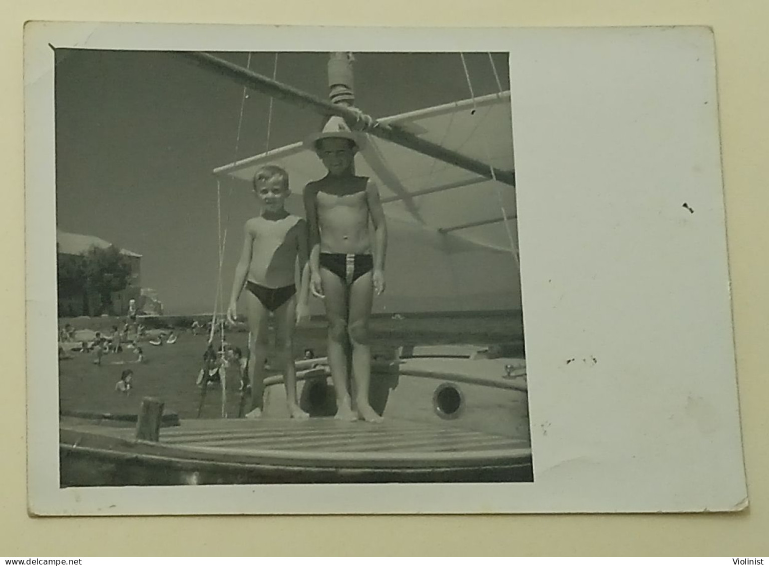 Two Boys Are Standing On A Boat At Sea - Personnes Anonymes