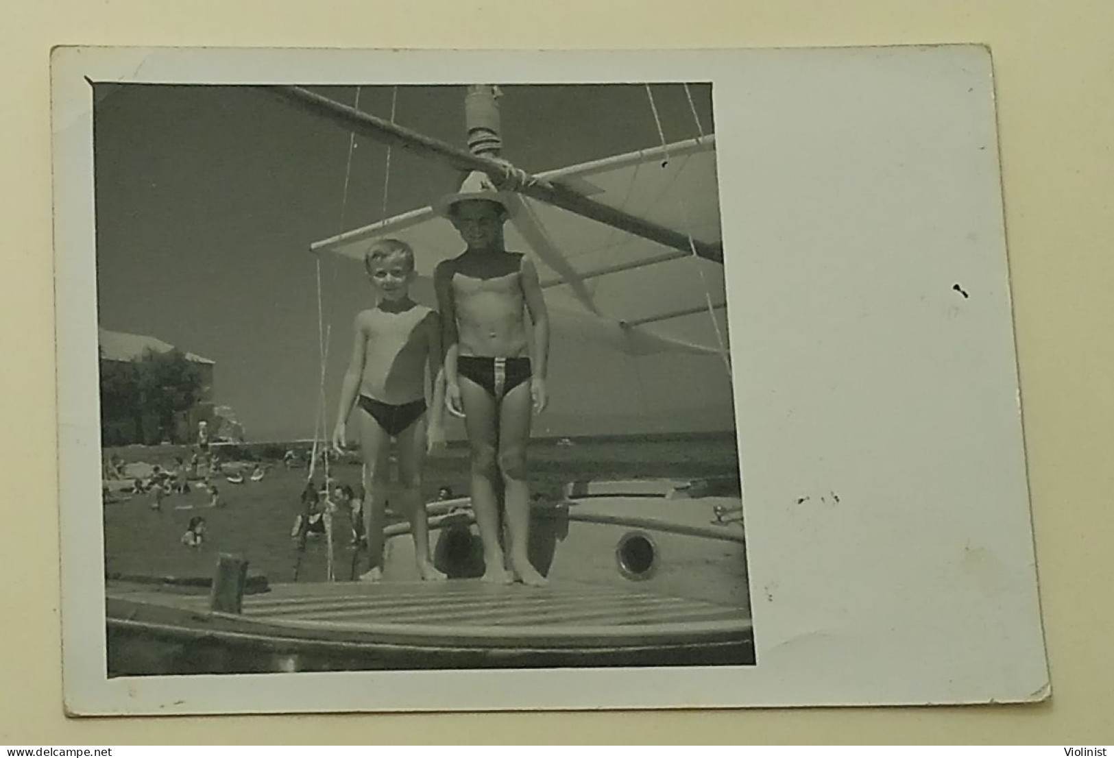 Two Boys Are Standing On A Boat At Sea - Personnes Anonymes