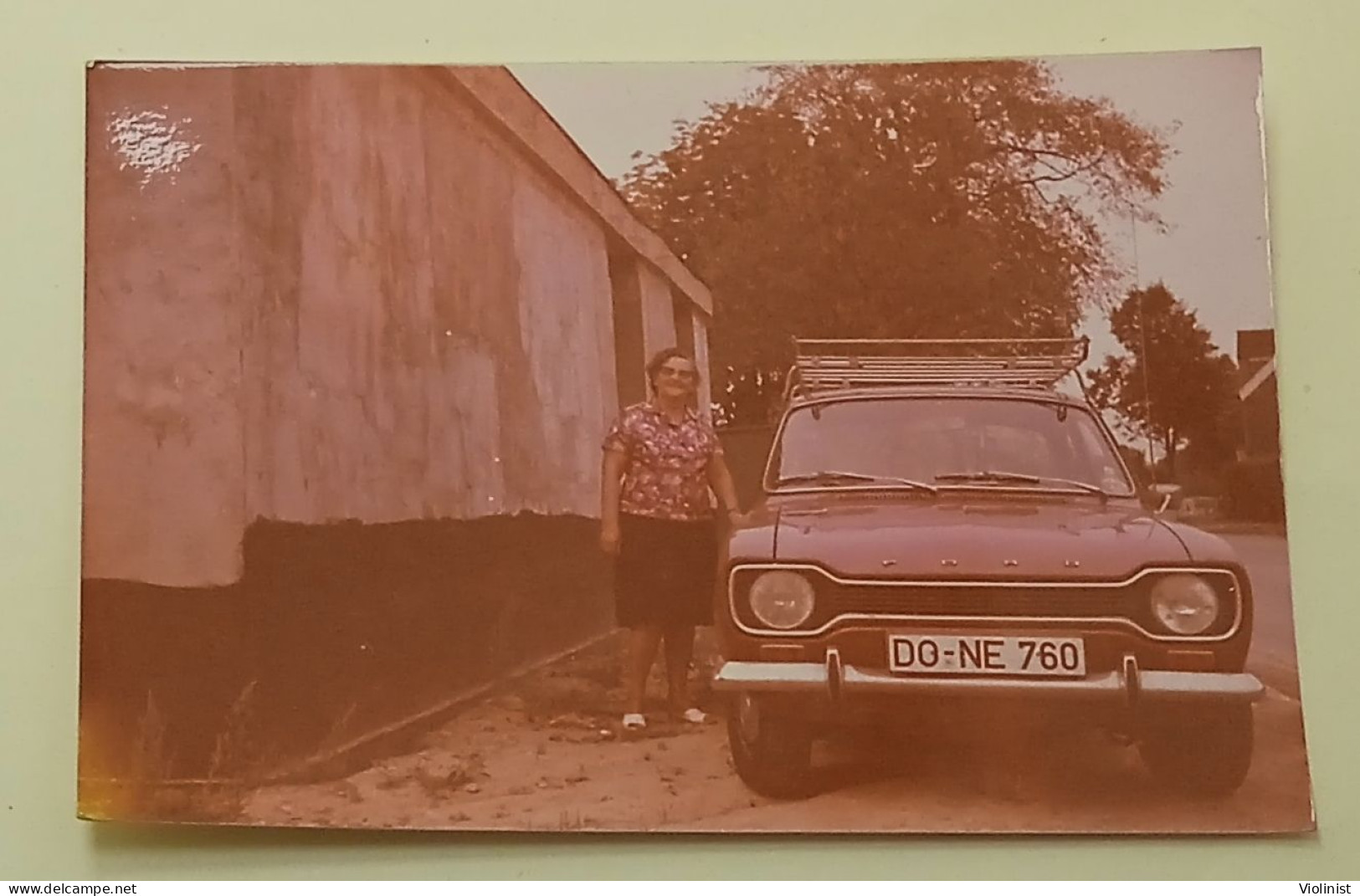 A Woman Next To A Ford Escort Car - Cars