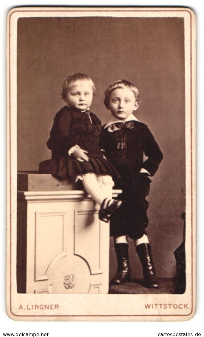 Fotografie A. Lingner, Wittstock, Oberkettenstr. 527, Portrait Junger Knabe Im Samtanszug Mit Seiner Schwester Im Kleid  - Anonieme Personen
