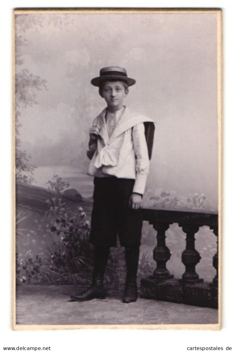 Fotografie Karl Schipper, Wiesbaden, Rheinstrasse 31, Portrait Junger Knabe In Schuluniform Mit Sommerhut Und Schulran  - Anonieme Personen