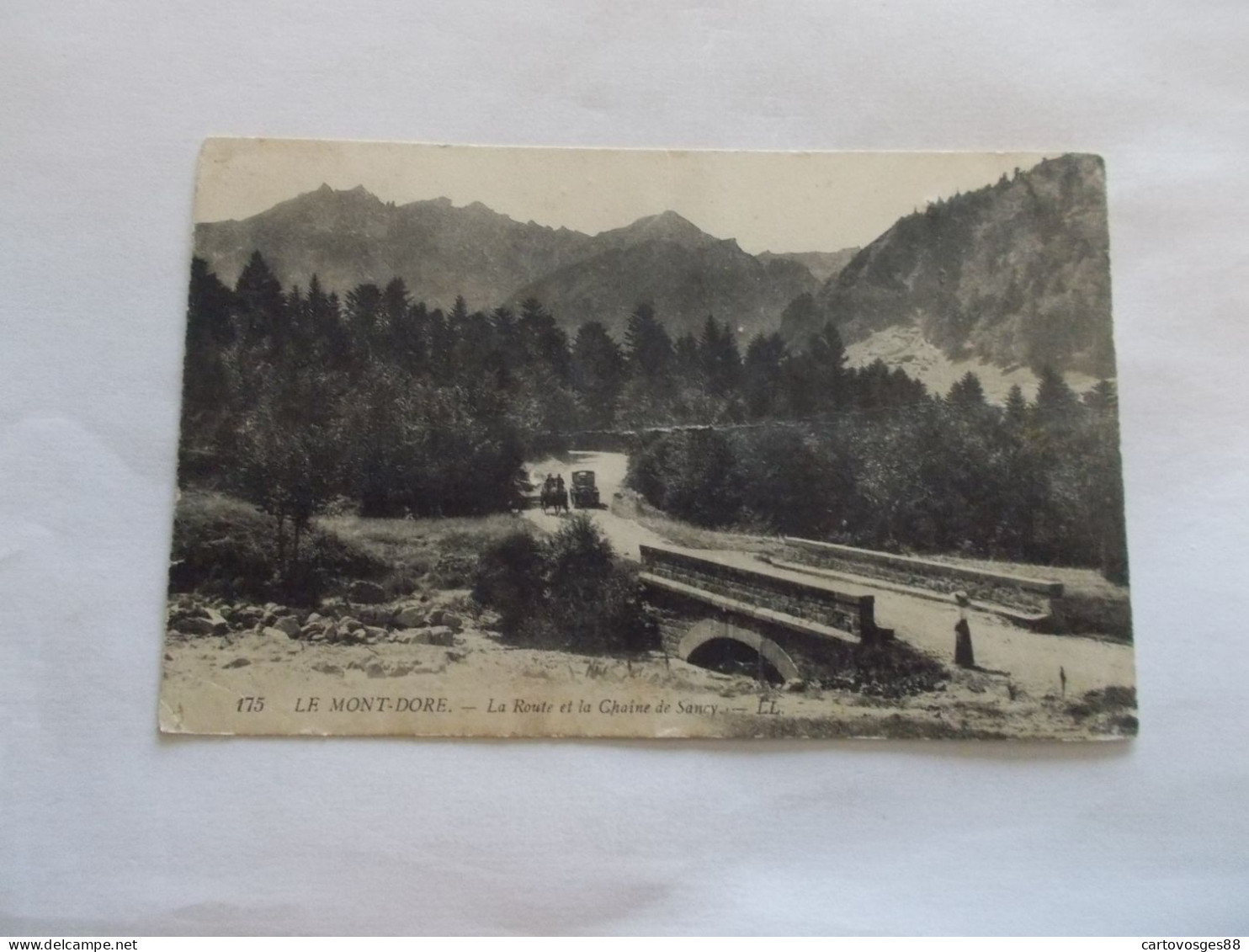 LE MONT DORE ( 63 Puy De Dome )  LA ROUTE ET LA CHAINE DE SANCY ANIMEES UNE VIEILLE AUTO DOUBLE UN ATTELAGE - Le Mont Dore