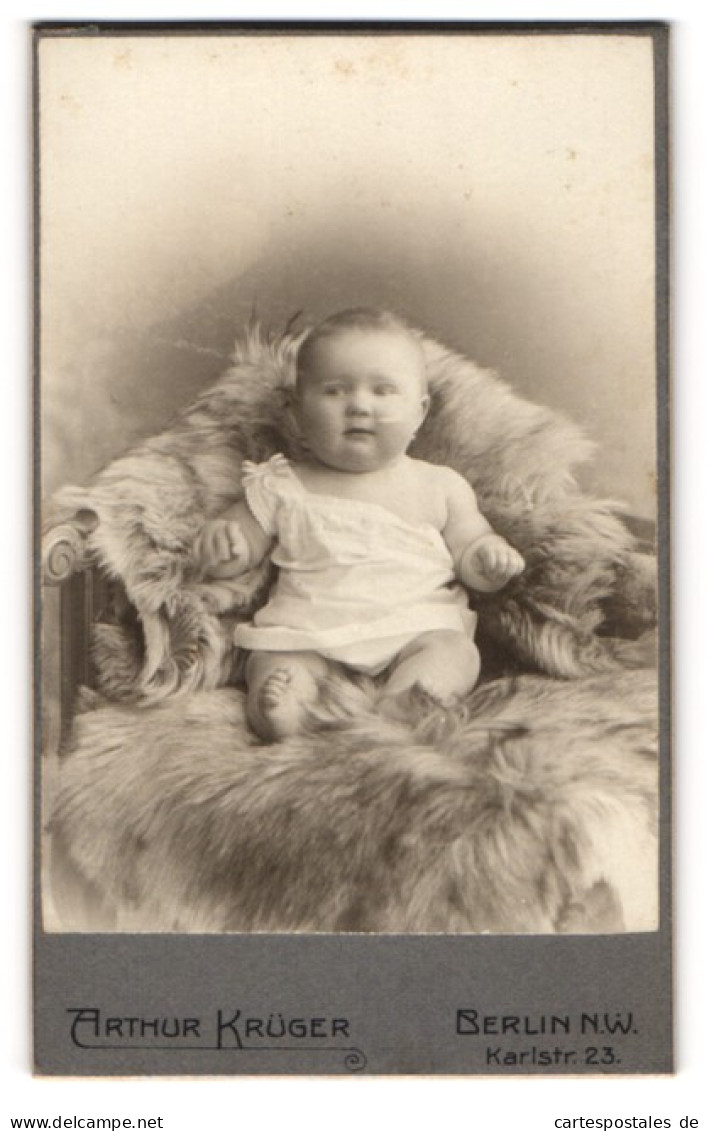 Fotografie Arthur Krüger, Berlin-NW, Portrait Niedliches Baby Im Weissen Hemd Auf Fell Sitzend  - Personnes Anonymes