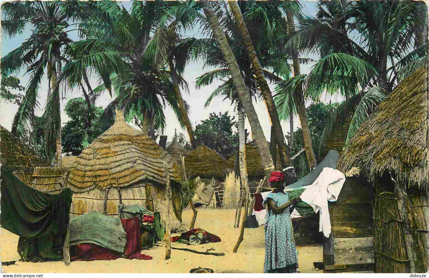 Afrique Noire - Femme Faisant Sécher Le Linge Au Mileu De Cases D'un Village Africain - Animée - Colorisée - Carte Dente - Non Classés