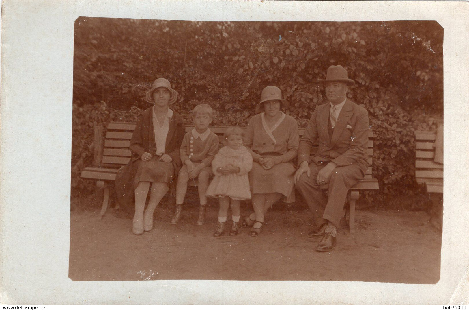 Carte Photo D'une Famille élégante Posant Assise Sur Un Banc Dans Un Jardin Public Vers 1920 - Personnes Anonymes