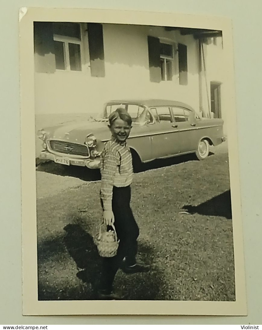 A Boy With A Small Basket In Front Of A Car - Anonymous Persons
