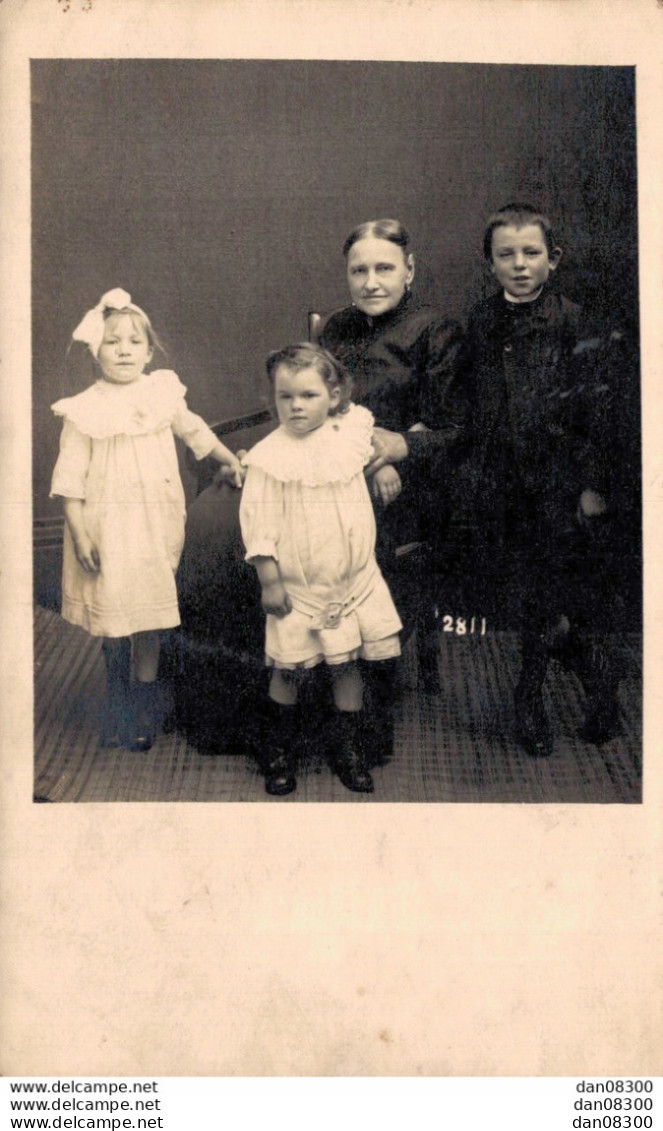 CARTE PHOTO NON IDENTIFIEE REPRESENTANT UNE FEMME ET TROIS ENFANTS DANS UN STUDIO PHOTO - A Identifier