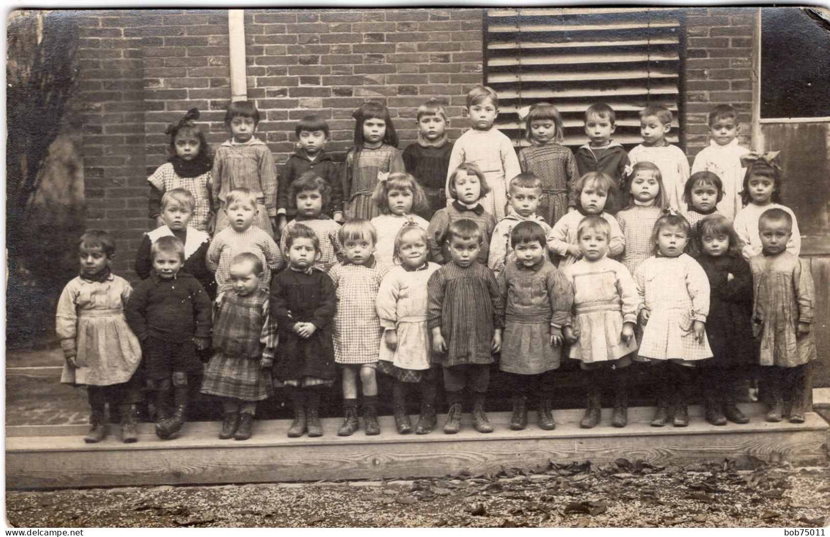 Carte Photo D'une Classe De Petit Enfants Posant Devant Leurs école - Anonymous Persons