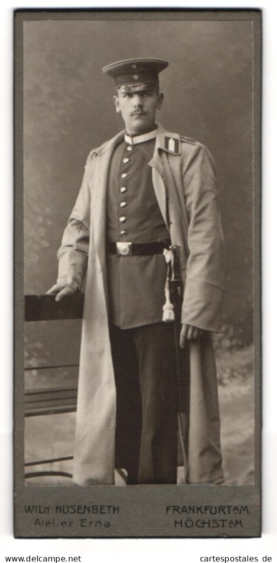 Fotografie Wilh. Husenberth, Frankfurt A. M., Kaiserstrasse 5a, Junger Soldat In Uniform Mit Bajonett Im Mantel  - Anonieme Personen