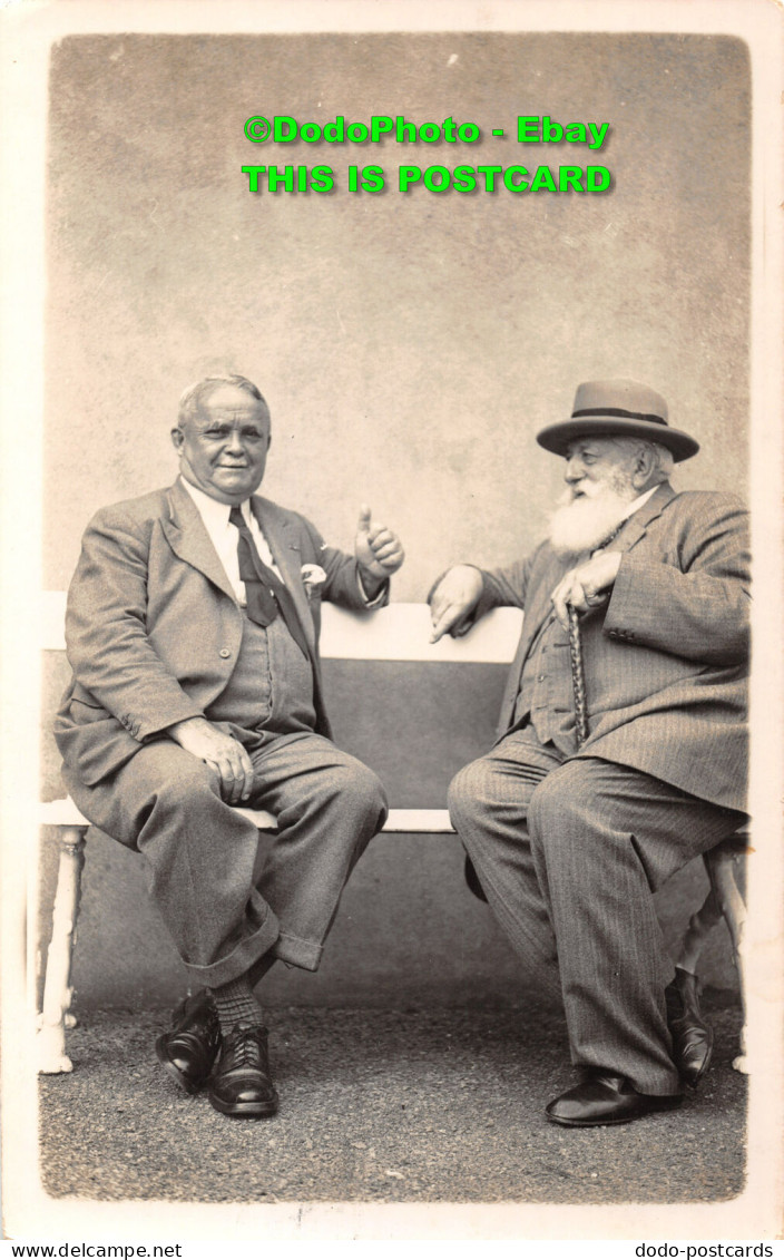 R359463 Two Men Are Sitting On A Bench. A Man With A Beard And A Hat And A Walki - World