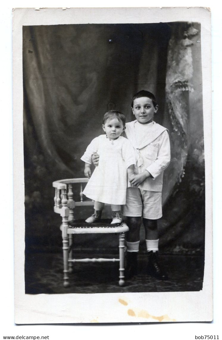 Carte Photo D'un Jeune Garcon élégant Avec Une Petite Fille Posant Dans Un Studio Photo - Personnes Anonymes