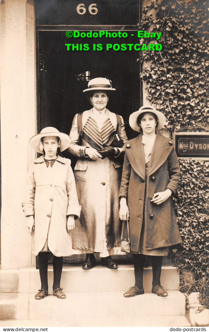 R419622 A Woman With Two Children Is Standing At The House - Welt