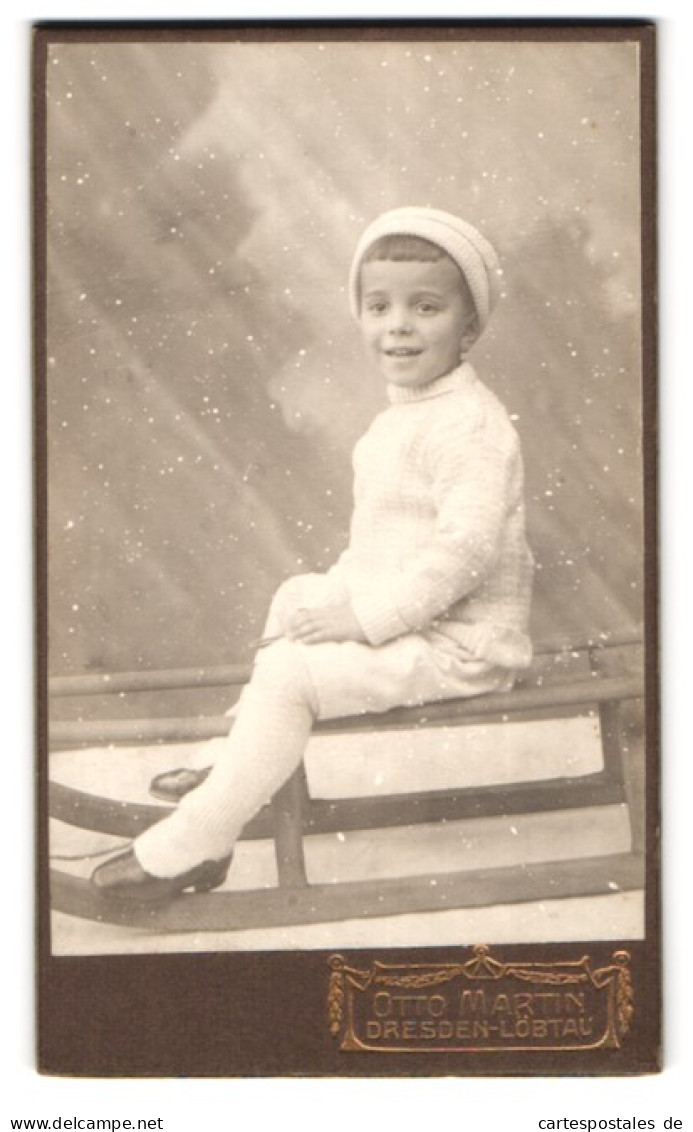 Fotografie Otto Martin, Dresden, Portrait Junger Knabe In Winterkleidung Mit Strumpfhose Auf Seinem Schlitten Sitzend  - Anonyme Personen