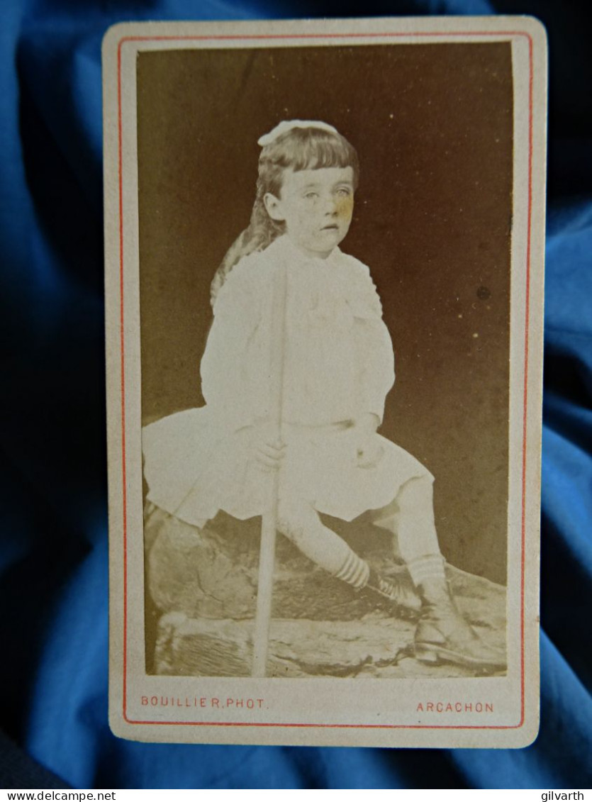Photo CDV Bouillier  Arcachon  Petite Fille En Robe (garçon ?) Assise Tenant Un Bâton Chaussettes Rayées  CA 1875 - L447 - Anciennes (Av. 1900)