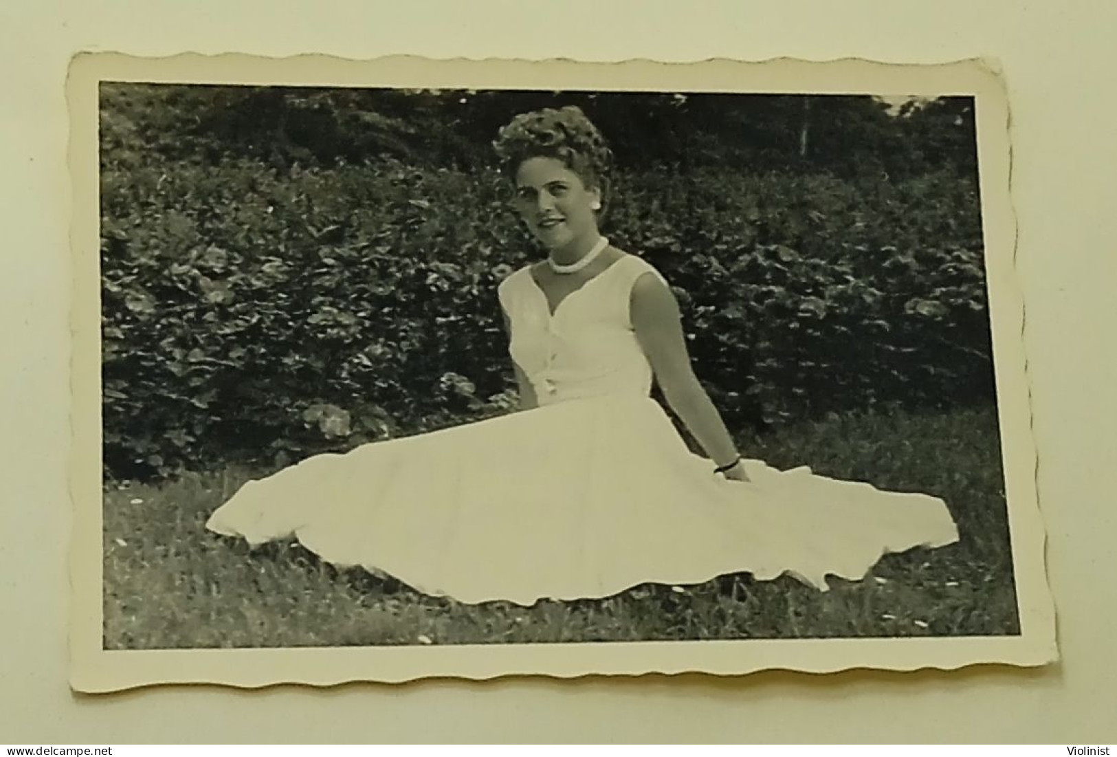 A Woman Sits On The Grass As Her White Dress Spreads - Anonymous Persons