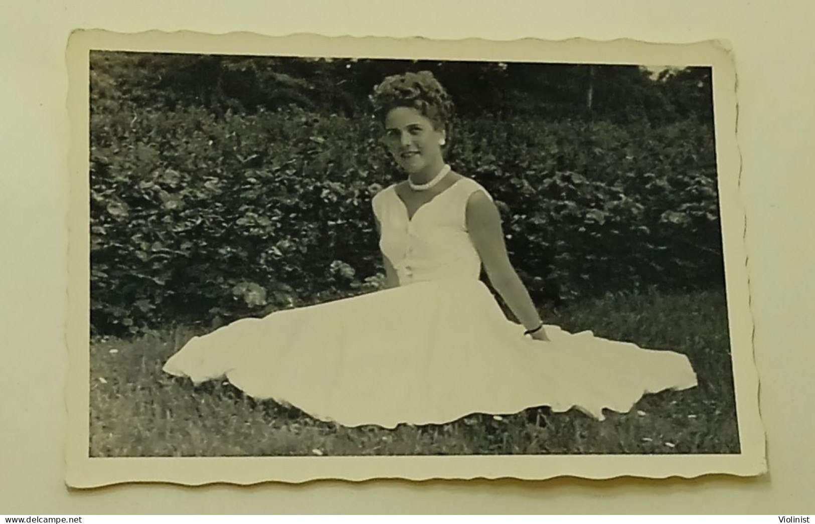 A Woman Sits On The Grass As Her White Dress Spreads - Anonymous Persons