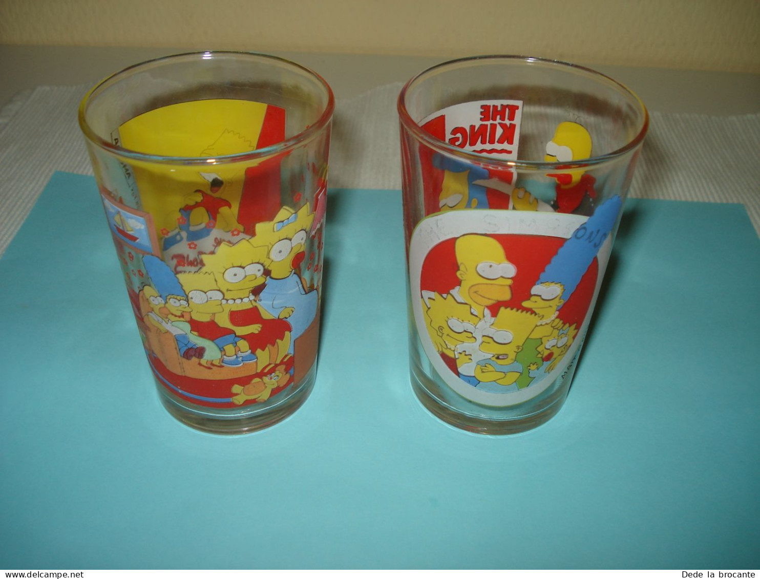 O20 ( 6 ) / Lot De 2 Verres De Collection - Amora - Les Simpsons - 1997 Et 1998 - Advertisement