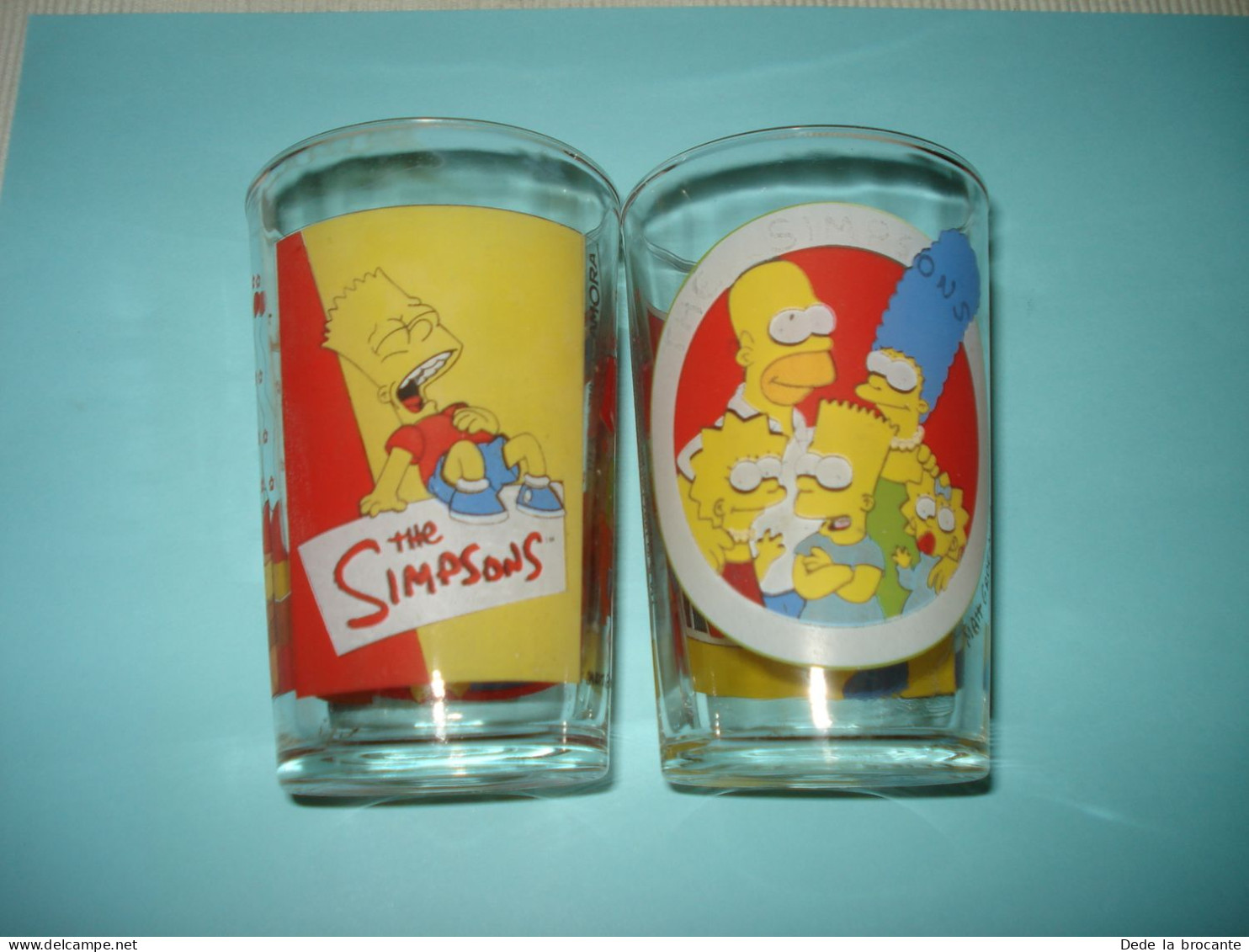 O20 ( 6 ) / Lot De 2 Verres De Collection - Amora - Les Simpsons - 1997 Et 1998 - Advertisement