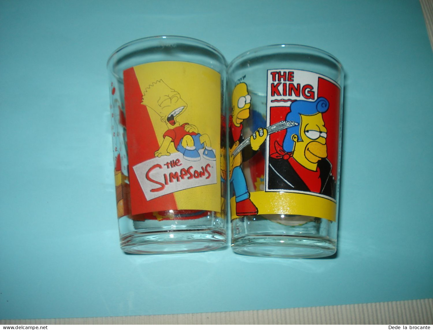 O20 (7)Lot De 2 Verres De Collection - Amora - Les Simpsons - 1997 Et 1999 - Advertisement