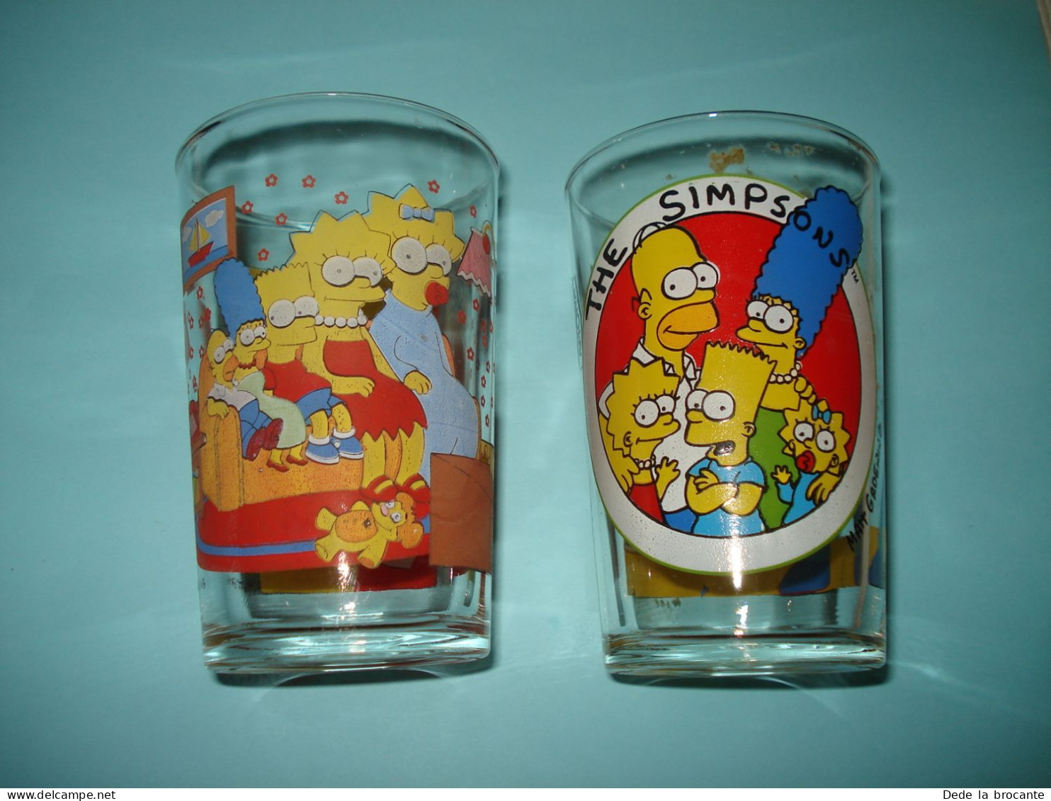 O20 (7)Lot De 2 Verres De Collection - Amora - Les Simpsons - 1997 Et 1999 - Advertisement
