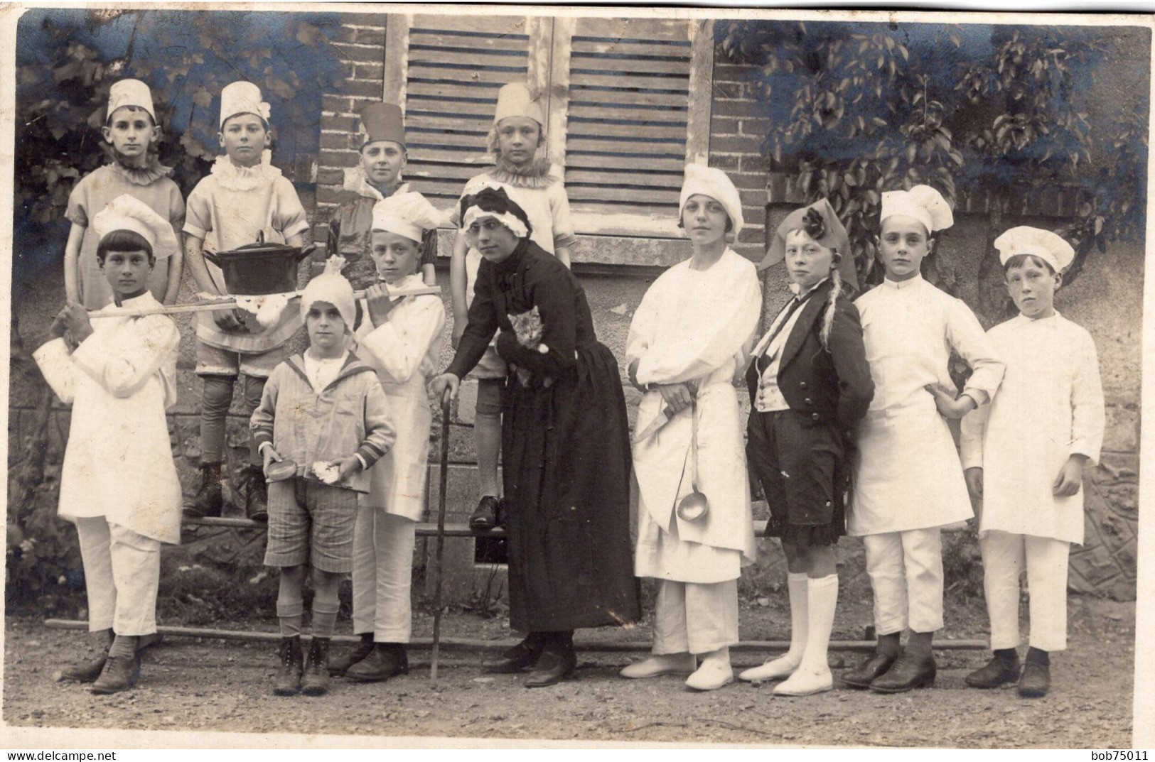 Carte Photo De Jeune Garcon Déguisé En Cuisinier Et En Grand-mére Posant Dans La Cour De Leurs école - Personnes Anonymes