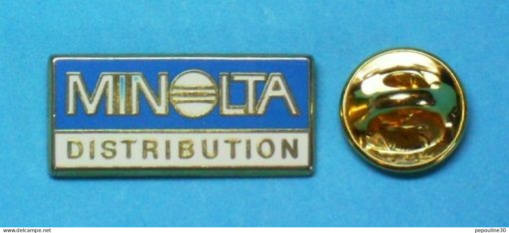 1 PIN'S  //   ** MINOLTA / DISTRIBUTION ** . (Arthus Bertrand Paris) - Informatica