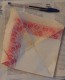 Serviette En Papier Pliée En Triangle Sans Marque Mais Avec Motifs Géométriques Rouges - Tovaglioli Con Motivi