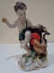 Figura De Porcelana. Chico Asustado Por Un Gallo. Marca En La Base Con Una Corona Y Un Pájaro. - Otros & Sin Clasificación