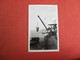 RPPC   Men Hoisted By Crane          Black Paper Residue On Back     Ref. 3084 - To Identify