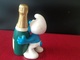 FIGURINE SCHTROUMPF QUI SOUHAITE UN "HAPPY SMURFDAY" PEYO MADE IN GERMANY OBJET DÉRIVÉ BANDE DESSINÉE - Figurines En Plastique