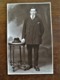 Oude Foto-kaart  In Donker Sepia  MAN MET HOED OP TAFEL  Door Fotograaf P . SCHELCK    AALST - Personnes Identifiées