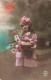 ENFANT - Fillette Avec Un Bouquet De Fleurs - Ruban Roses Dans Les Cheveux - Carte Postale Ancienne - Autres & Non Classés