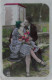 COUPLES - Une Femme Tenant Un Bouquet De Fleur - Un Homme - Un Couple S'enlaçant - S'embrassant - Carte Postale Ancienne - Couples