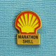 1 PIN'S /  ** MARATHON " SHELL " PARCOURIR LA PLUS LONGUE DISTANCE AVEC 1L DE CARBURANT ** . (B.I. Promocourse) - Otros & Sin Clasificación