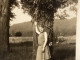 Photo Snapshot 1920 Cannes Belle Femme, Jeune Fille En Robe La Main En L’air Contre Un Arbre Montagne Derrière Derrière - Anonymous Persons