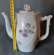 Delcampe - Cafetière En Porcelaine, Blanche Motif Floral Violet. Un Casse Sur Le Bec Verseur. - Altri & Non Classificati