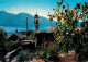 13302560 Brione Ortsmotiv Mit Kirche Sonnenblumen Blick Auf Lago Maggiore Brione - Autres & Non Classés