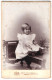 Fotografie Carl Bestel, Minden, Kleines Mädchen Mit Weissem Kleid Sitzt Auf Einem Tisch  - Anonieme Personen
