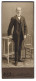 Fotografie Gustav Mühlfriedel, Wilkau I. S., Feiner Herr Im Anzug Steht Zwischen Tisch Und Stuhl  - Personnes Anonymes