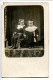Photo Carte Datée 1915 Deux Jeunes Enfants (en Studio) Grand Col Châle En Dentelle Pour L'un L'autre Assis Sur Fauteuil - Portraits