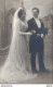 CARTE PHOTO NON IDENTIFIEE REPRESENTANT UN COUPLE LE JOUR DU MARIAGE POSANT DANS UN STUDIO PHOTO - A Identifier