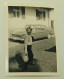 A Boy With A Small Basket In Front Of A Car - Anonymous Persons