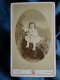 Photo CDV Touzery Orléans  Petite Fille En Robe Assise Tenant Une Poupée  CA 1885-90 - L442 - Anciennes (Av. 1900)